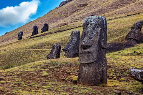 Several Moai statues on a grassy hill under cloudy skies on Easter Island, The Moai statues on