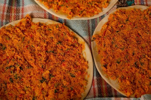 Traditional Turkish Biberli Ekmek Flat bread with red pepper paste being prepared before cooking in