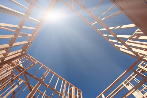 New Construction Framing Abstract with Sunburst Over Clear Blue Sky