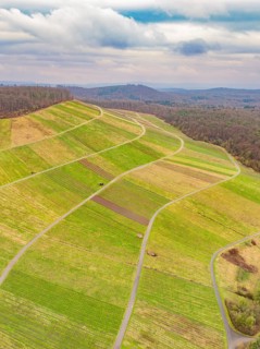 Winding hills and fields seen from the air, under an overcast sky, Großbottwar, Ludwigsburg