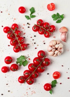 Branch with mini cherry tomatoes, with spices and herbs, garlic, food background, top view, on a