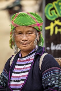 Portrait of an elderly woman in colourful traditional dress with headscarf and large earrings,
