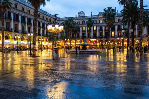 Nightlife at Plaça Reial, lanterns by Gaudi in the historic centre of Barcelona, Spain