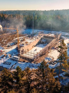Construction site in the snowy forest with scaffolding and towering construction crane, new fire