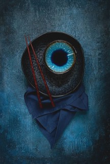 Food background, with an empty black plate, a bowl, wooden chopsticks, with a napkin, on a blue