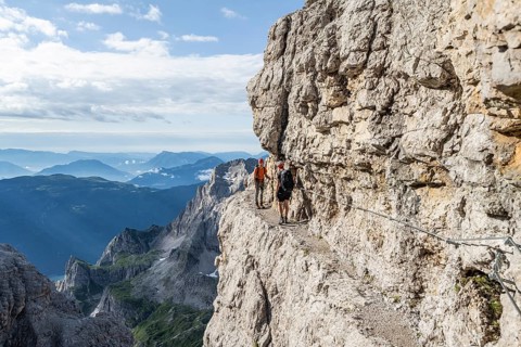 Two mountaineers climb an exposed rock band in the secured Via Ferrata Bocciere Centrale via