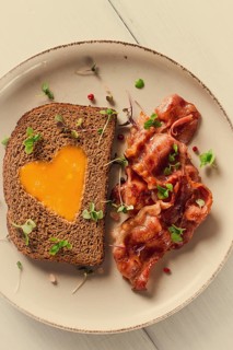 Breakfast, fried egg with bacon, micro-green, on a light background, no people, selective focus