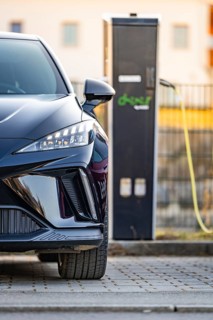 Front view of a black electric car next to a charging station, Deer E- Carsharing vehicle MG4,