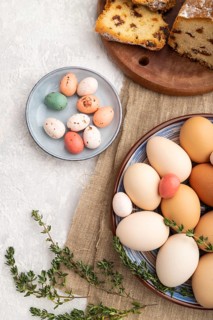 Homemade easter pie with raisins and eggs on plate on a gray concrete background and linen textile.