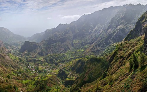 Panorama, panoramic view, lush green valley in the midst of a majestic mountain landscape under