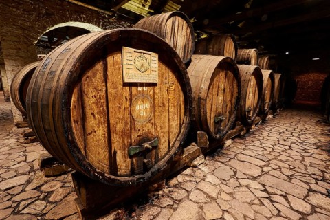 Wooden barrels on a stone floor in a wine-cellar-like setting, Achaia Clauss winery, Patras,