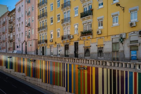 LISBON, PORTUGAL - MAY 20, 2025: Colorful wall above the road and buildings