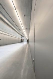 A long corridor in a modern, industrial style, with concrete walls and minimalist aesthetics,