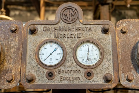Historic pressure and vacuum pressure gauges on a cast iron steam engine from the manufacturer