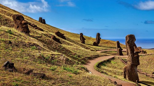 Several moai along a wind path on a sunny hill under a blue sky, the moai statues on Easter Island