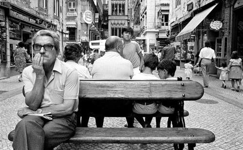 A man sits on a bench in the historic city center of Lisbon, Lisbon, Portugal