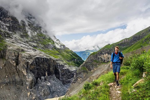Mountaineer on a hiking trail, cloudy mountain landscape, Bernese Alps, Bernese Oberland,