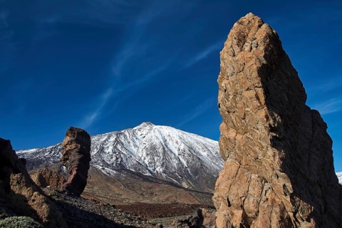 Roques de Garcia, Two distinctive rocks against snow-covered mountain under blue sky, Teide, Parque