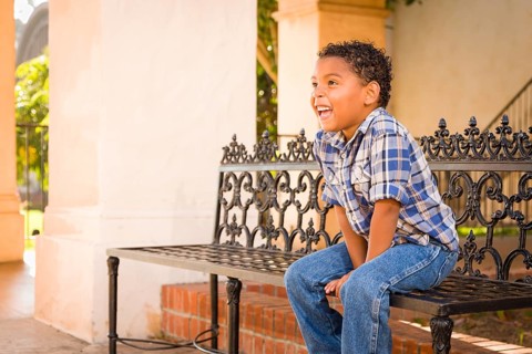 Handsome African American and Mexican Boy Sitting on Park Bench
