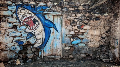 Blue shark wall mural, graffiti on dilapidated stone wall with door, Ribeira Grande, Santo Antao,