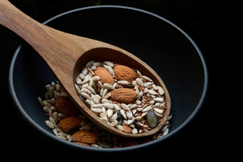 Kernels in ladle, kernel mix of almond kernels, sunflower seeds, linseeds and pumpkin seeds