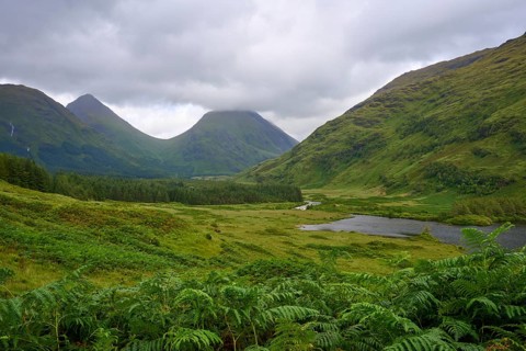 A green valley with a small lake, framed by rolling hills and a cloudy sky, Loch Etive, Argyll and