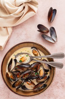 Mussels in creamy garlic sauce, served with fresh herbs and spices, homemade, no people