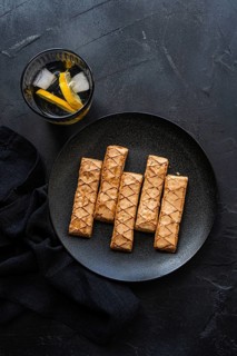 A delicious puff pastry filled with sweet apricot jam, elegantly arranged on a dark textured plate.