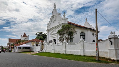 White church with decorative architecture in a historic setting under blue skies, The historic