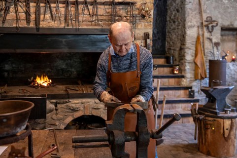 An elderly blacksmith in Salzburg, Austria, diligently maintains the age-old traditions of
