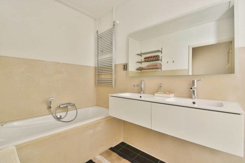 A contemporary bathroom featuring a sleek double sink vanity, modern fixtures, and a spacious