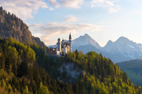 Castle on a hill in front of a majestic mountain panorama, Neuschwanstein, Schwangau near Füssen,