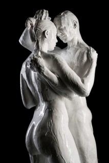 Nude couple with white color bodyart embracing shot in the dark room