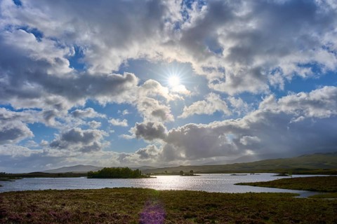 Beautiful landscape with lake and bright sun, illuminated by clouds, Rannoch Moor, Bridge of Orchy,
