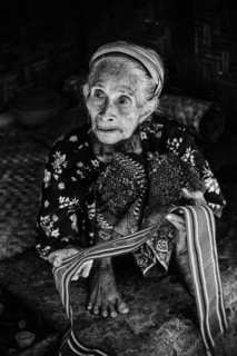 Old woman offering textiles for sale, textile, old age, human, work, colourful, clothing, village,