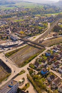 Urban area with railway lines, bridges and green areas in a residential area, PV plant at Obi