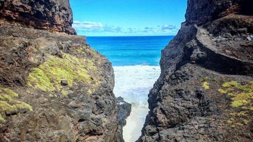 Hiking trail snakes along Narrow Cliff Gorge with views of the blue sea under clear skies, hiking,