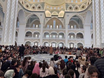 Dozens of Muslim children participate in indoor entertainment event inside a grand mosque during