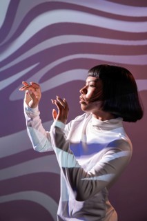 A futuristic Latin woman engages with an immersive virtual environment. She embodies modernity and