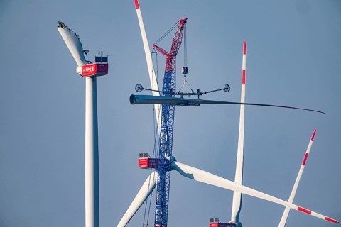 Dismantling a defective wind turbine, dismantling the two intact wings with a large crane, bent