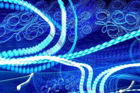 Dynamic abstract light patterns swirl and shift, creating a mesmerizing display of movement and
