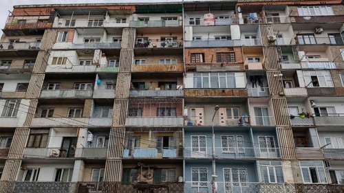 Front view of a symmetrical apartment block with many balconies and floors, Tbilisi, Georgia