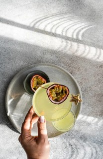 Top view of cropped unrecognizable person holding a glass of gin and tonic cocktail mixed with