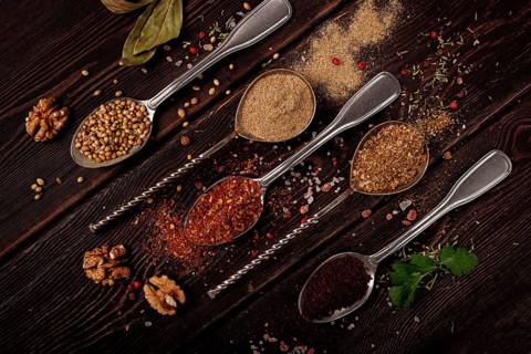 Georgian spices in spoons, on a wooden background, top view, no people