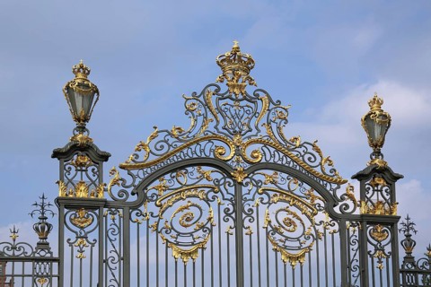 Magnificent golden metal gate with crown and lanterns, decorations, metal bars, ironwork, detail,