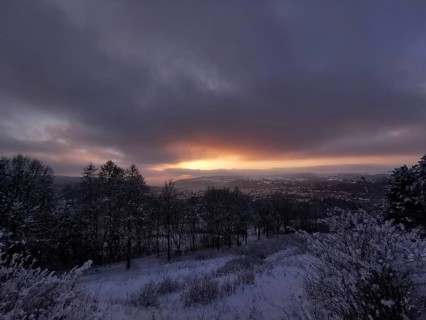 Snowy landscape at sunset with view of Rosenberg Kronach Fortress, Frankenwald nature park Park