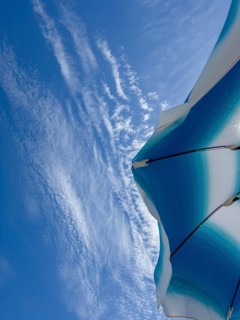 Parasol in front of a blue sky with clouds