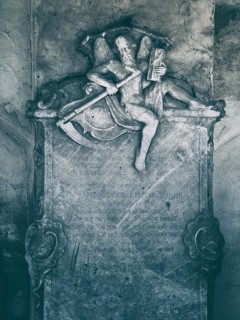 Old historic cemetery, sculpture of the Grim Reaper with scythe and hourglass as a detail of a