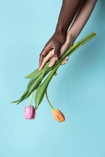 A close-up image captures the harmonious interaction of multiethnic hands, one male and one female,