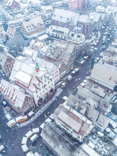 Aerial view of a snow-covered town with red roofs, Black Forest, Calw, Germany
